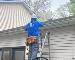 Professional installing gutters on a residential roof